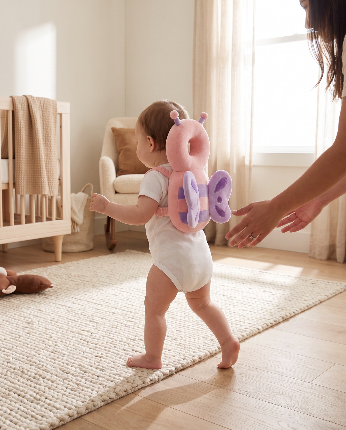 Toddler taking first steps wearing a pink bee head protector